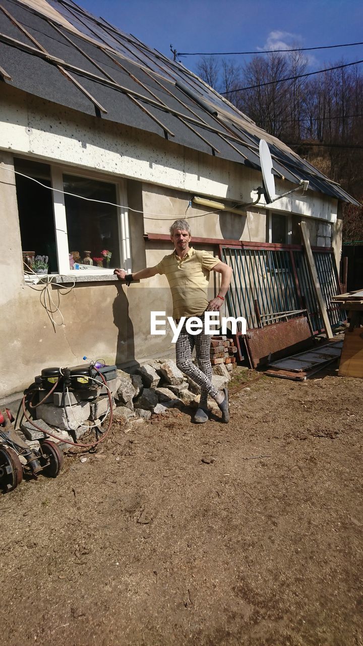 MAN STANDING OUTSIDE HOUSE