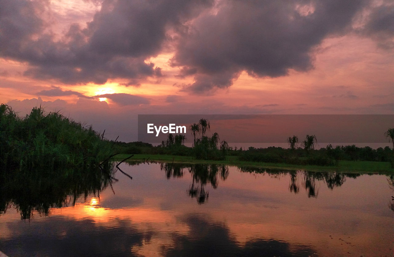 SCENIC VIEW OF LAKE AGAINST DRAMATIC SKY