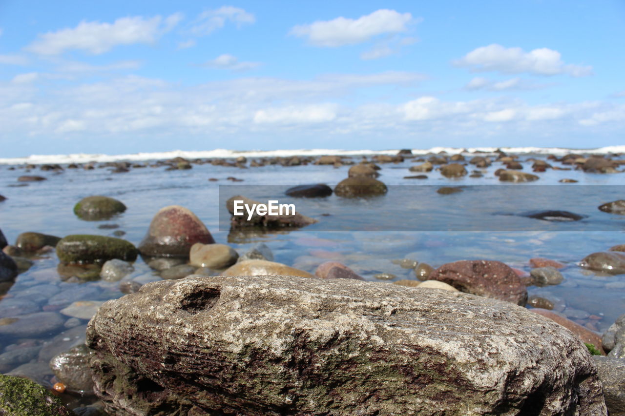 SCENIC VIEW OF ROCKS ON BEACH AGAINST SKY