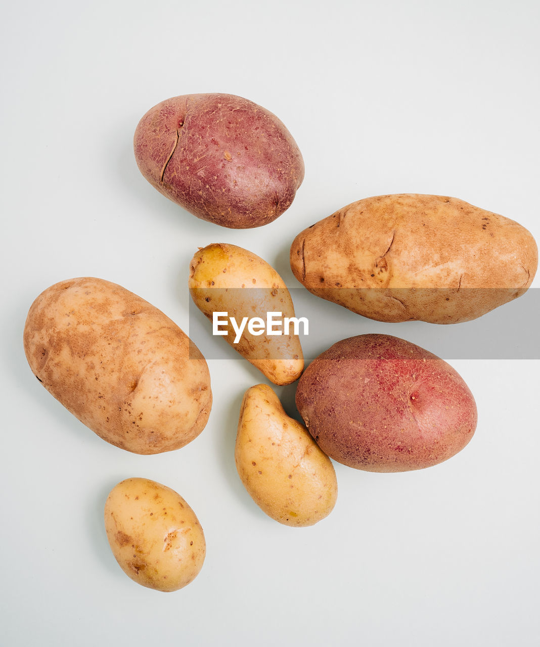 High angle view of three kinds of potatoes on white background