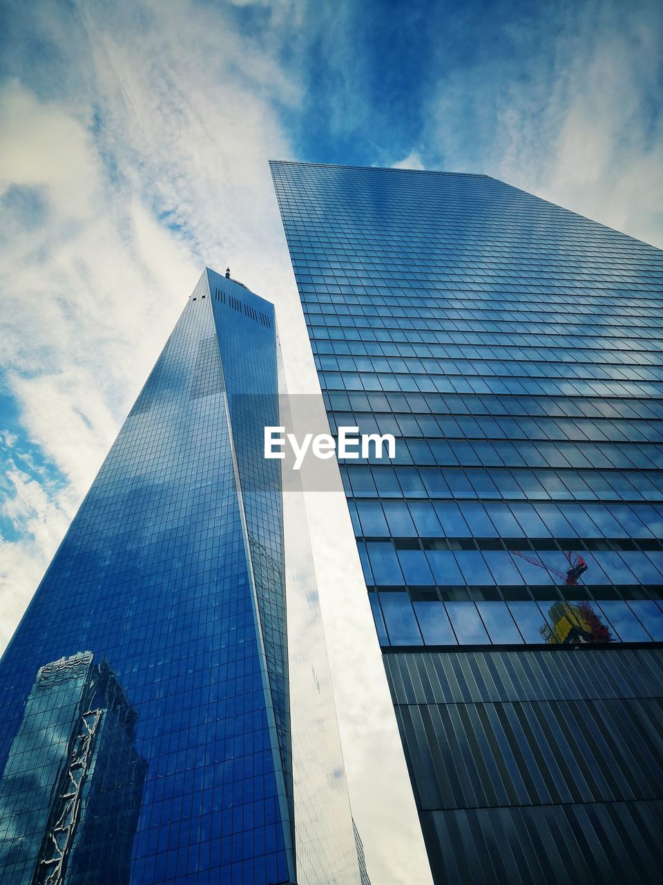 Low angle view of modern glass building against sky