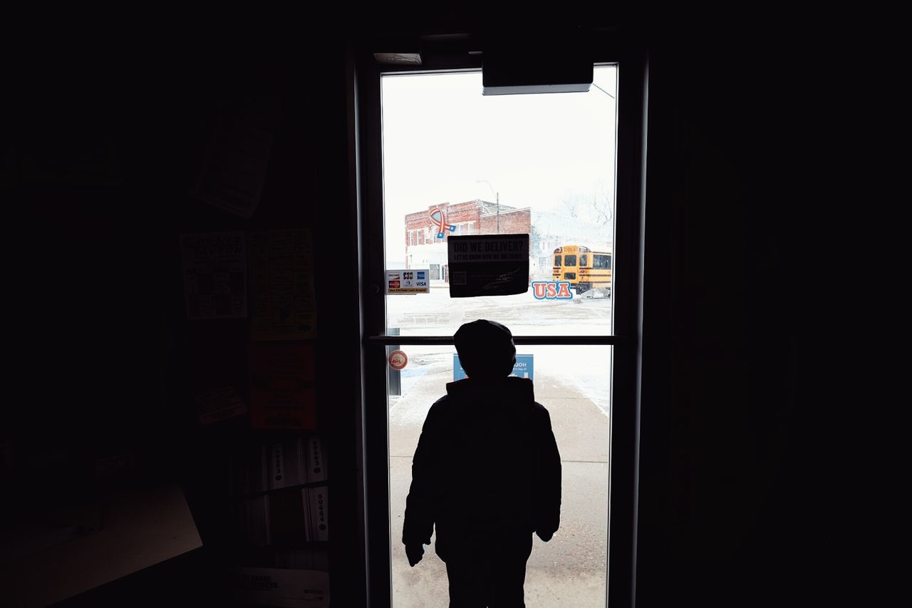 SILHOUETTE MAN LOOKING THROUGH WINDOW