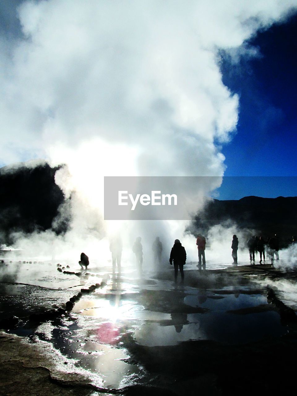 Tourists watching geyser erupt