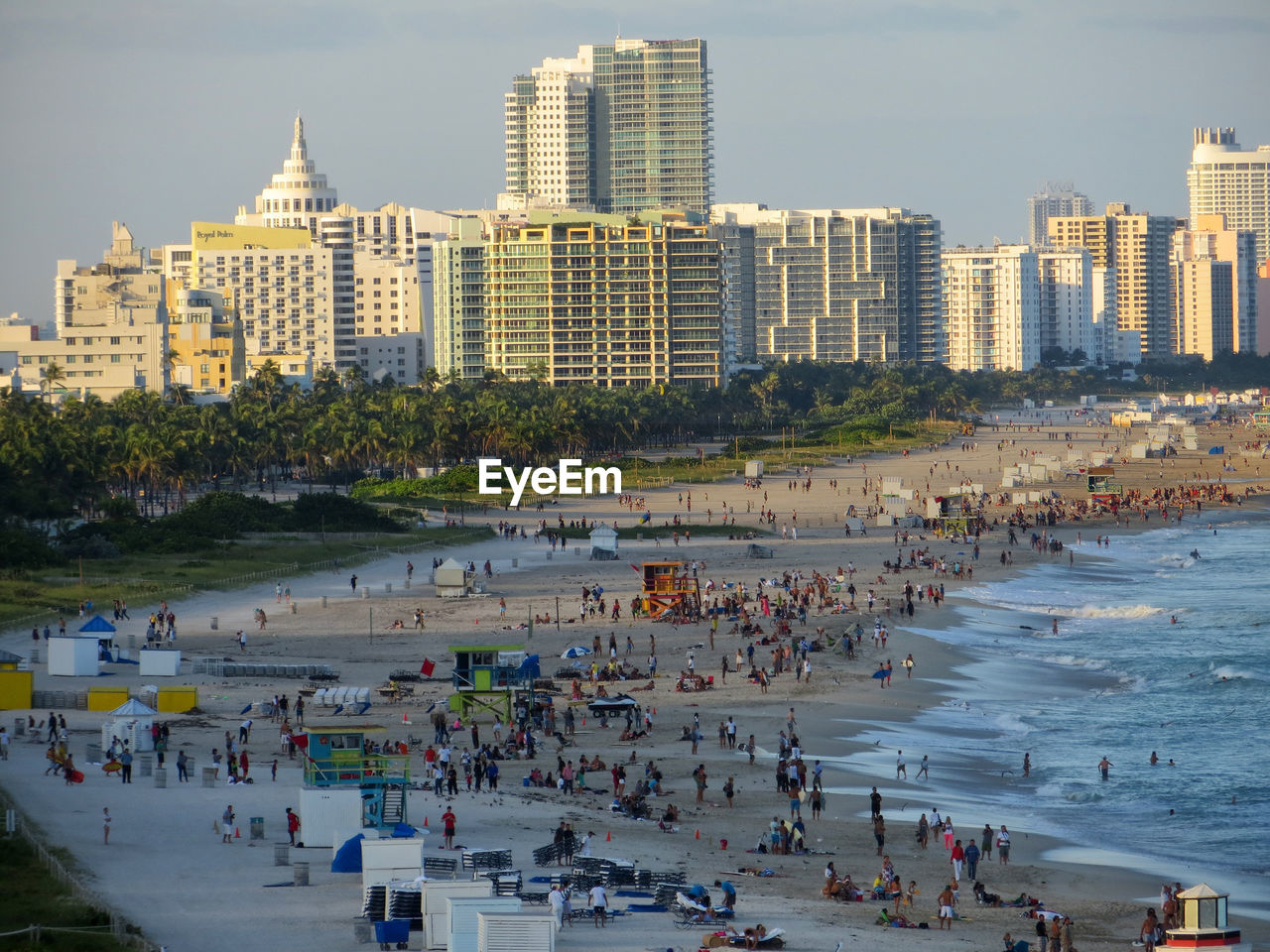 PANORAMIC VIEW OF PEOPLE AT BEACH AGAINST SKY