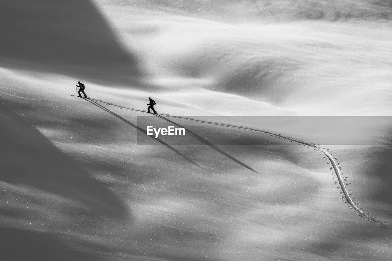 LOW ANGLE VIEW OF SILHOUETTE PEOPLE WALKING ON SKY