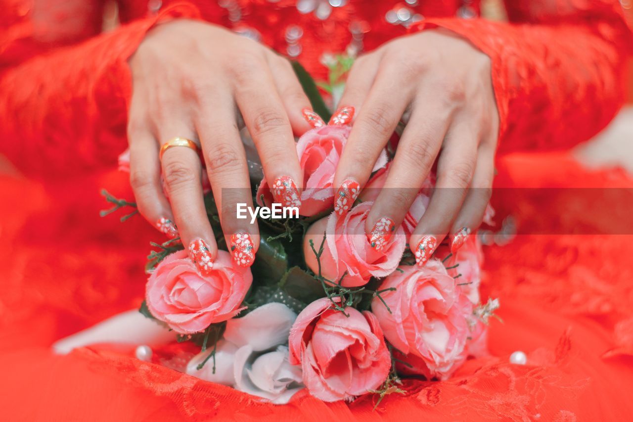 Midsection of woman sitting with flower bouquet