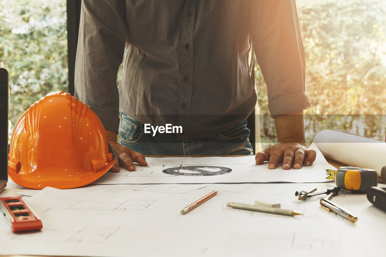 Midsection of man working on table