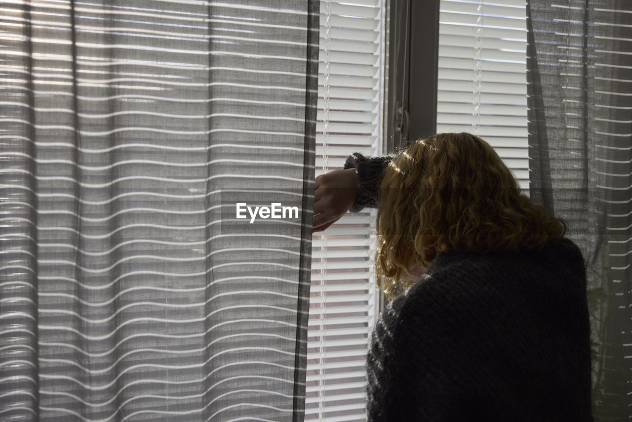 Teenage girl looking through window