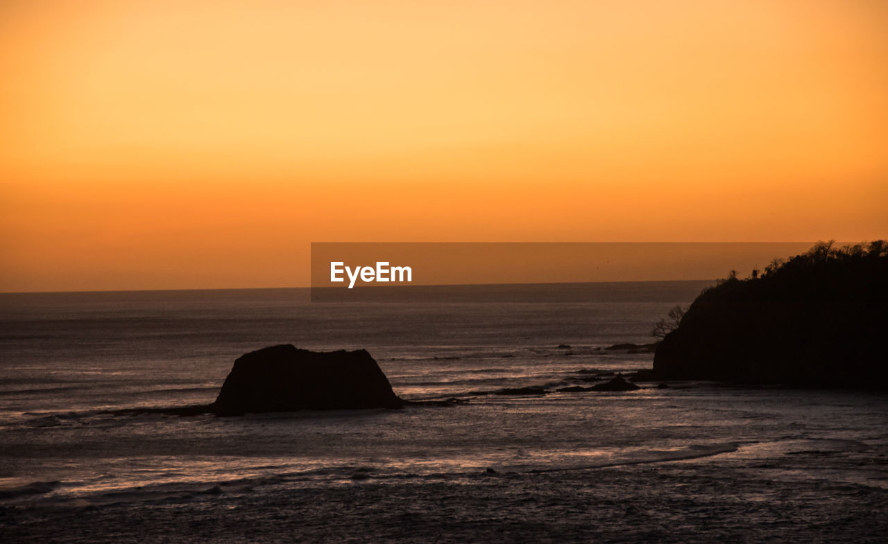 Scenic view of sea against orange sky