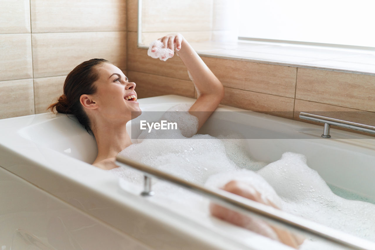 Rear view of woman in bathroom at home