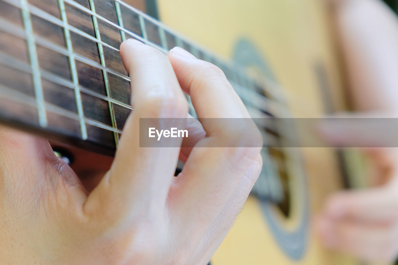 Cropped image of man playing guitar