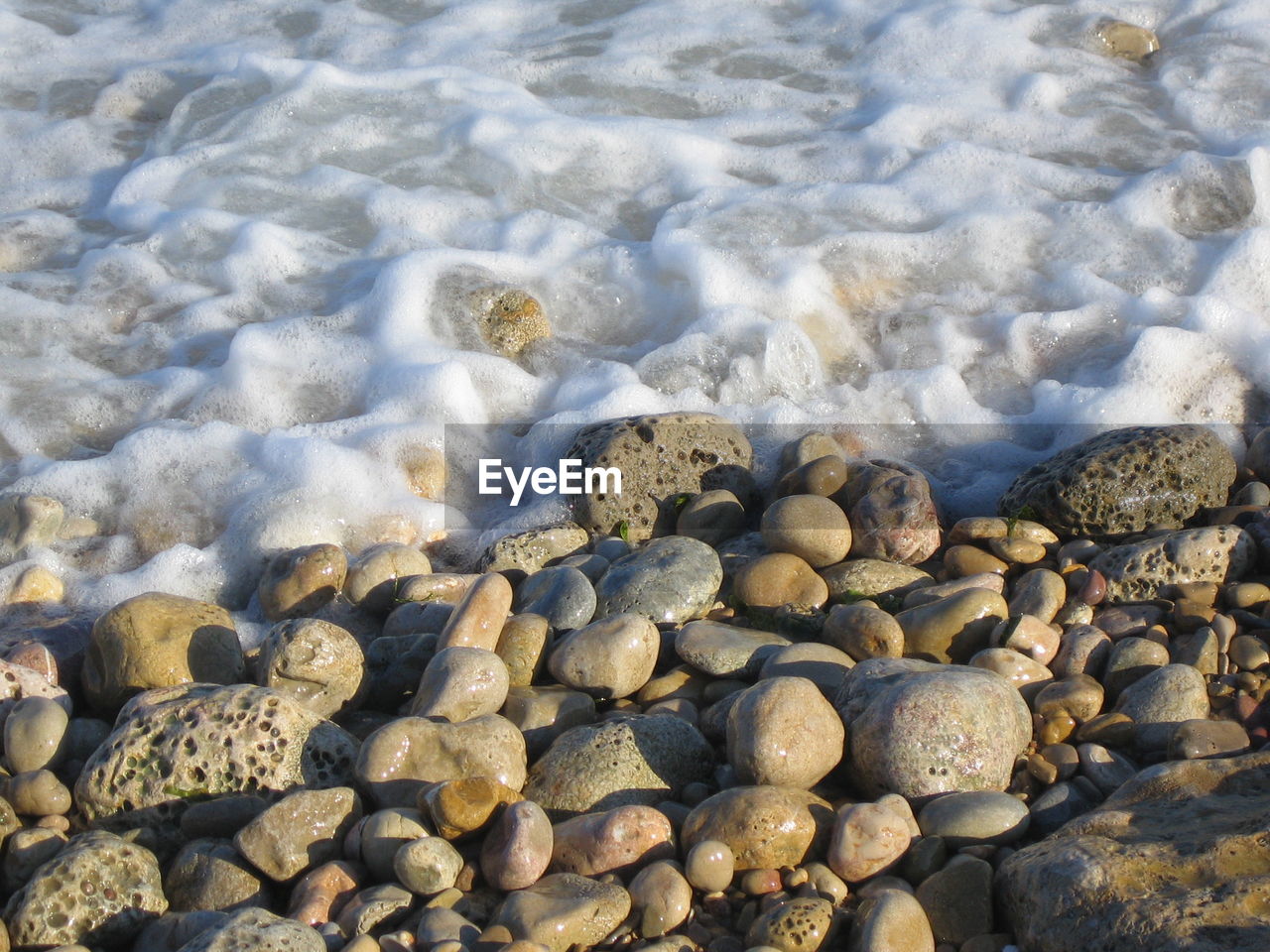 CLOSE-UP OF PEBBLES IN WATER