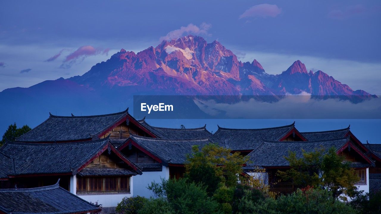 houses by mountains against sky