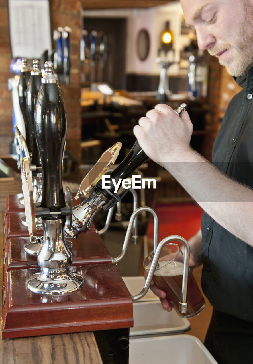 Bartender pulling beer at british pub