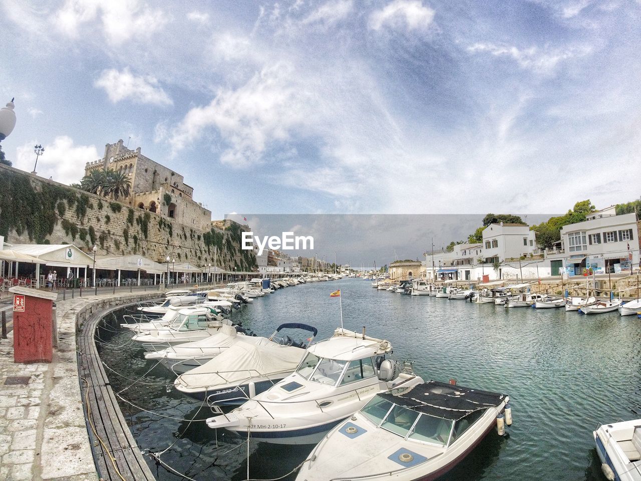 BOATS IN RIVER BY BUILDINGS AGAINST SKY