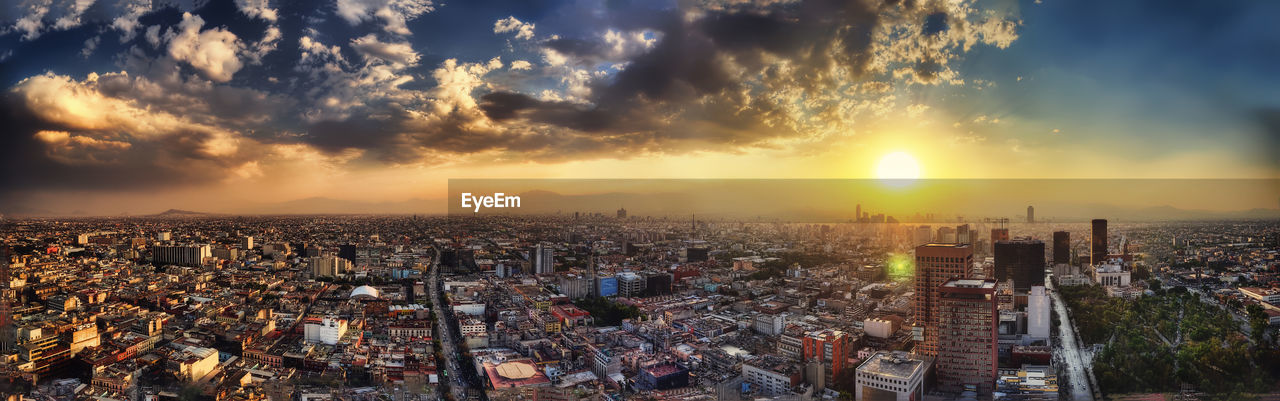 HIGH ANGLE VIEW OF BUILDINGS AGAINST SKY DURING SUNSET