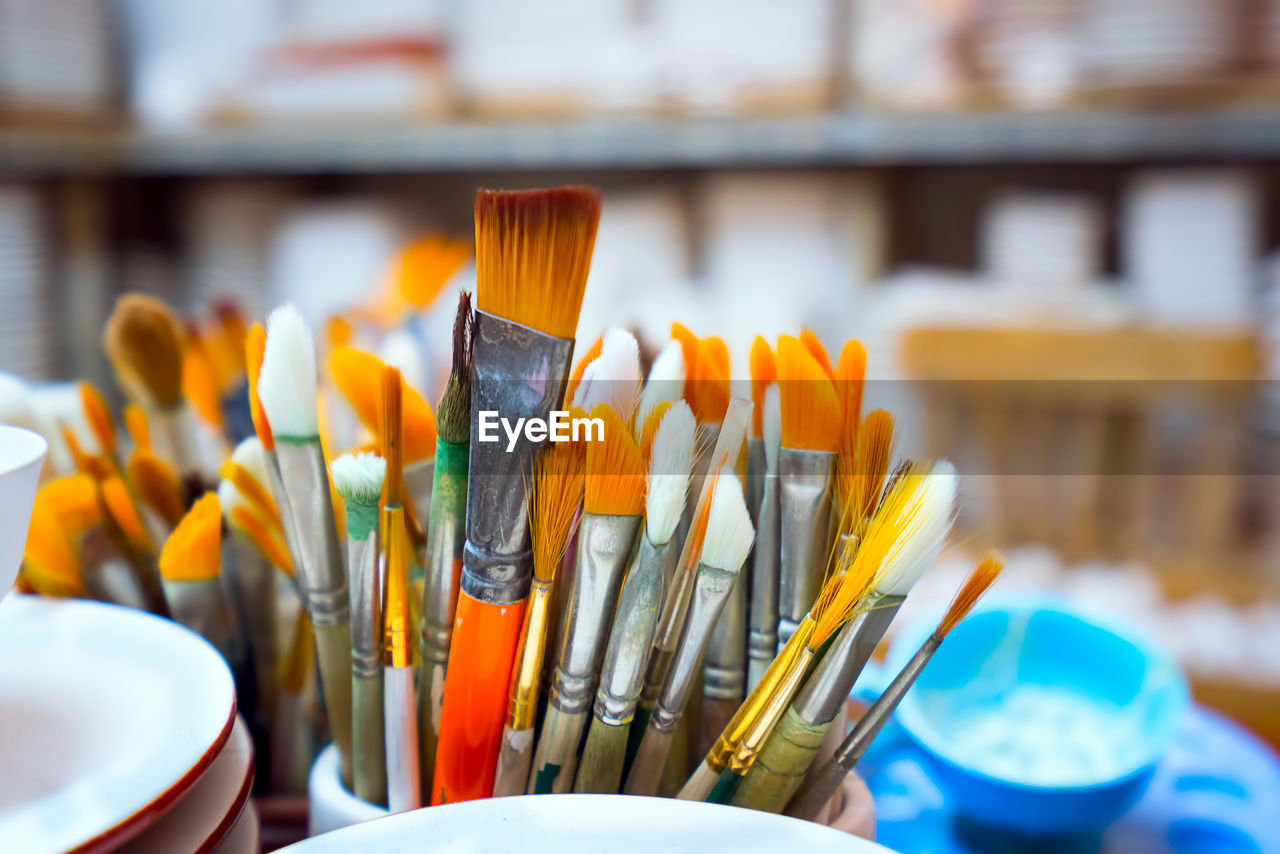 Close-up of various paintbrushes in container