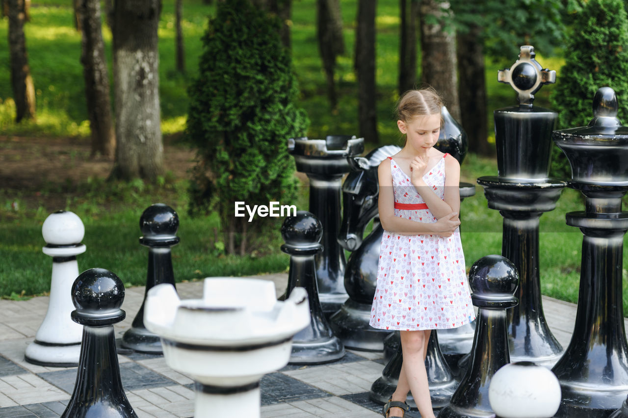 Girl standing on artificial chess board
