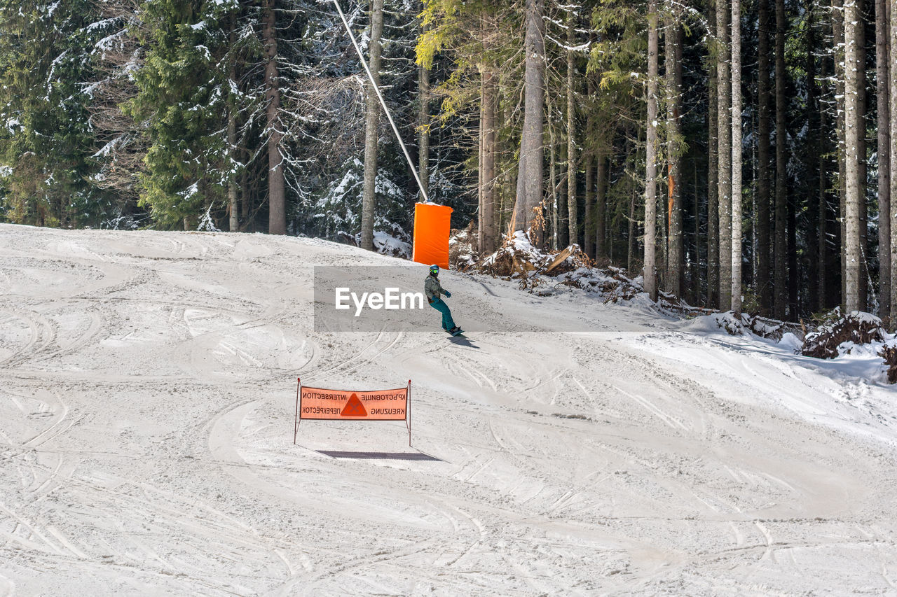 Person skiing on snow covered landscape during winter