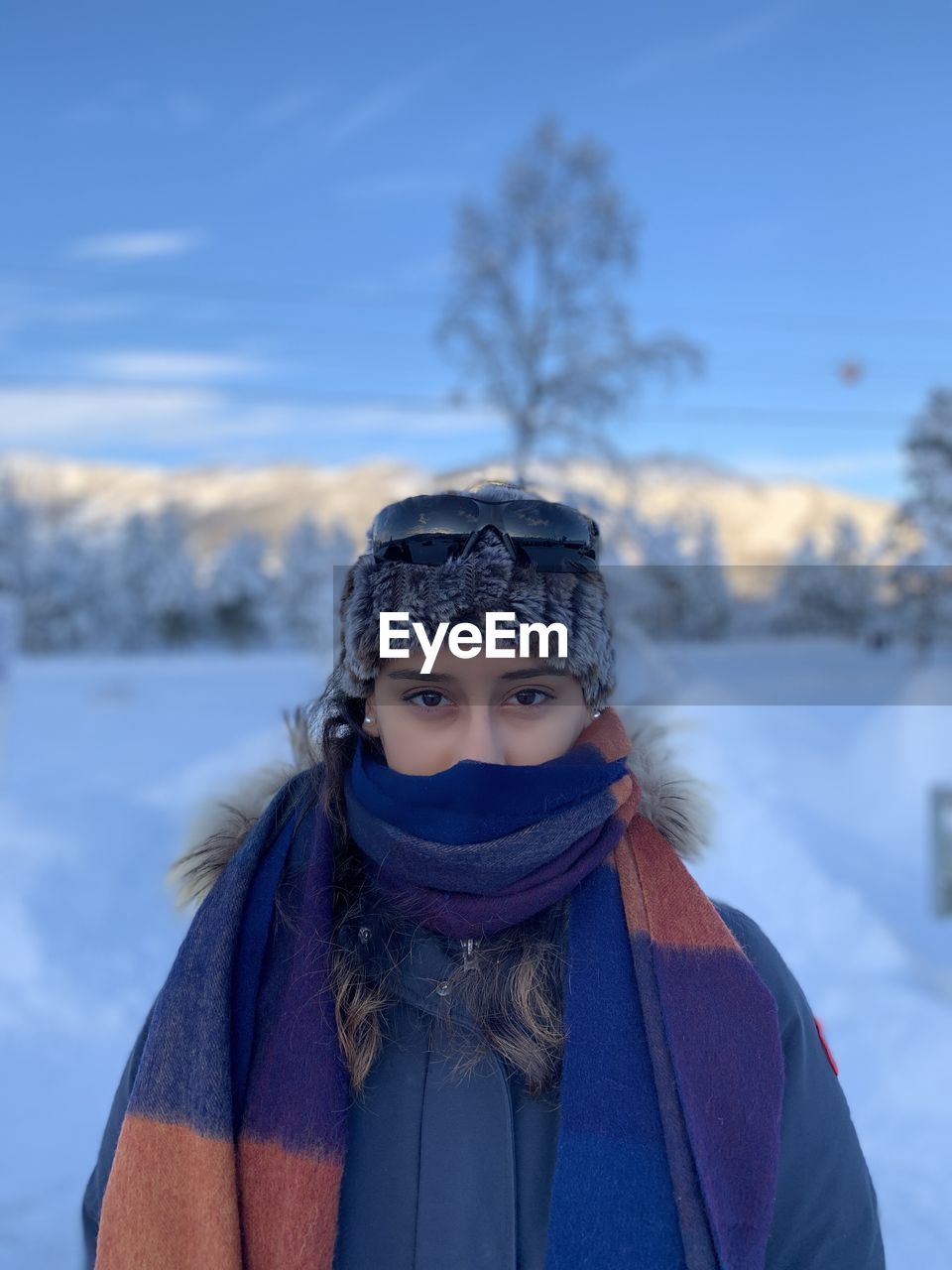Portrait of woman covering face with snow
