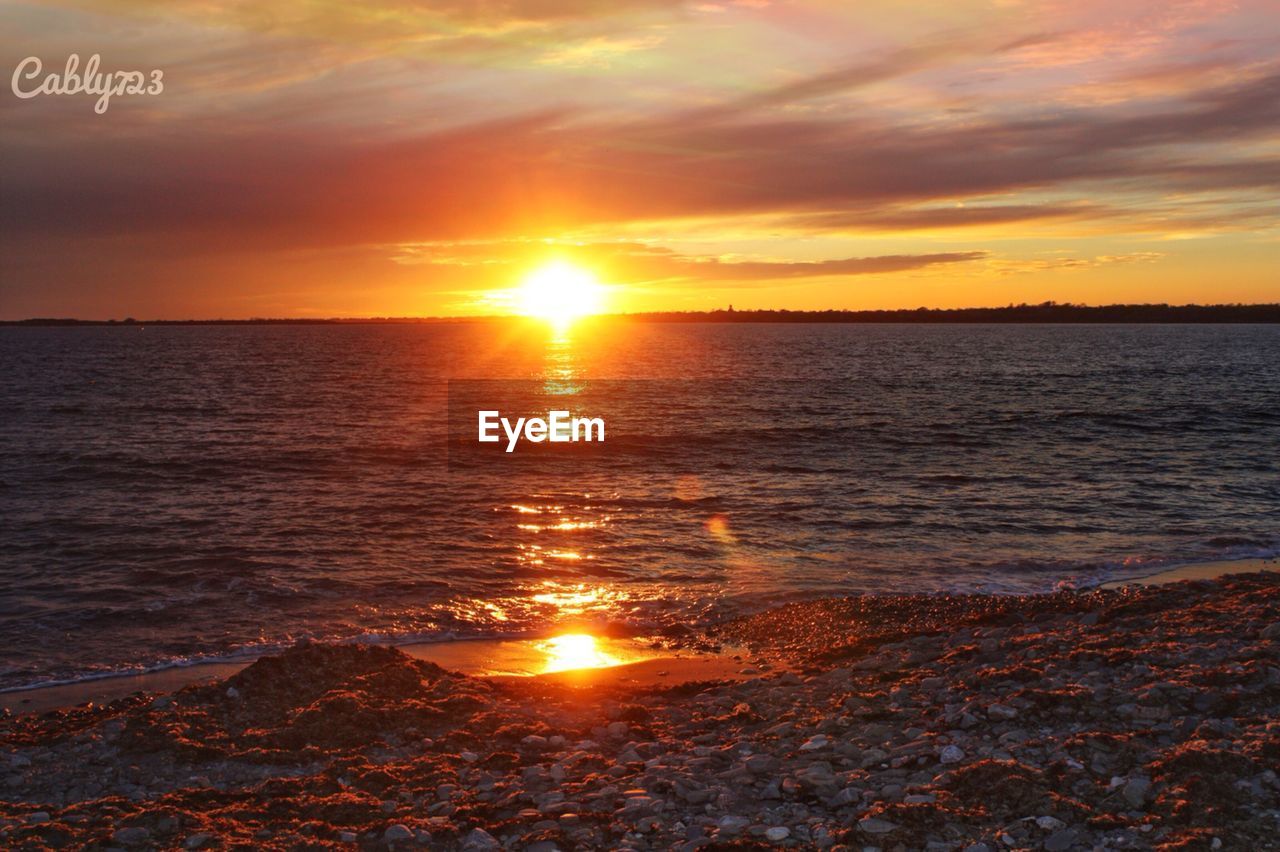 SCENIC VIEW OF BEACH AGAINST SKY DURING SUNSET