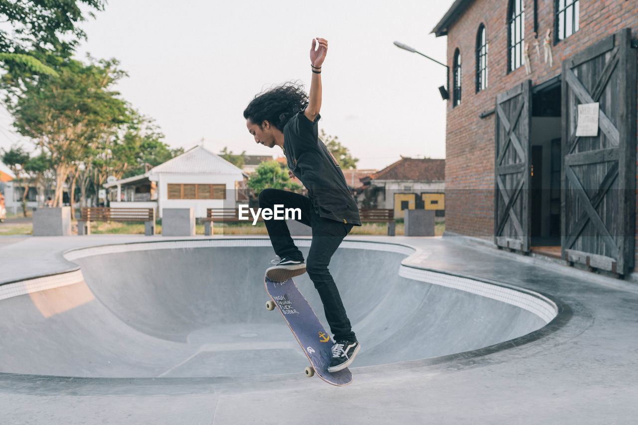 FULL LENGTH OF MAN SKATEBOARDING ON SKATEBOARD