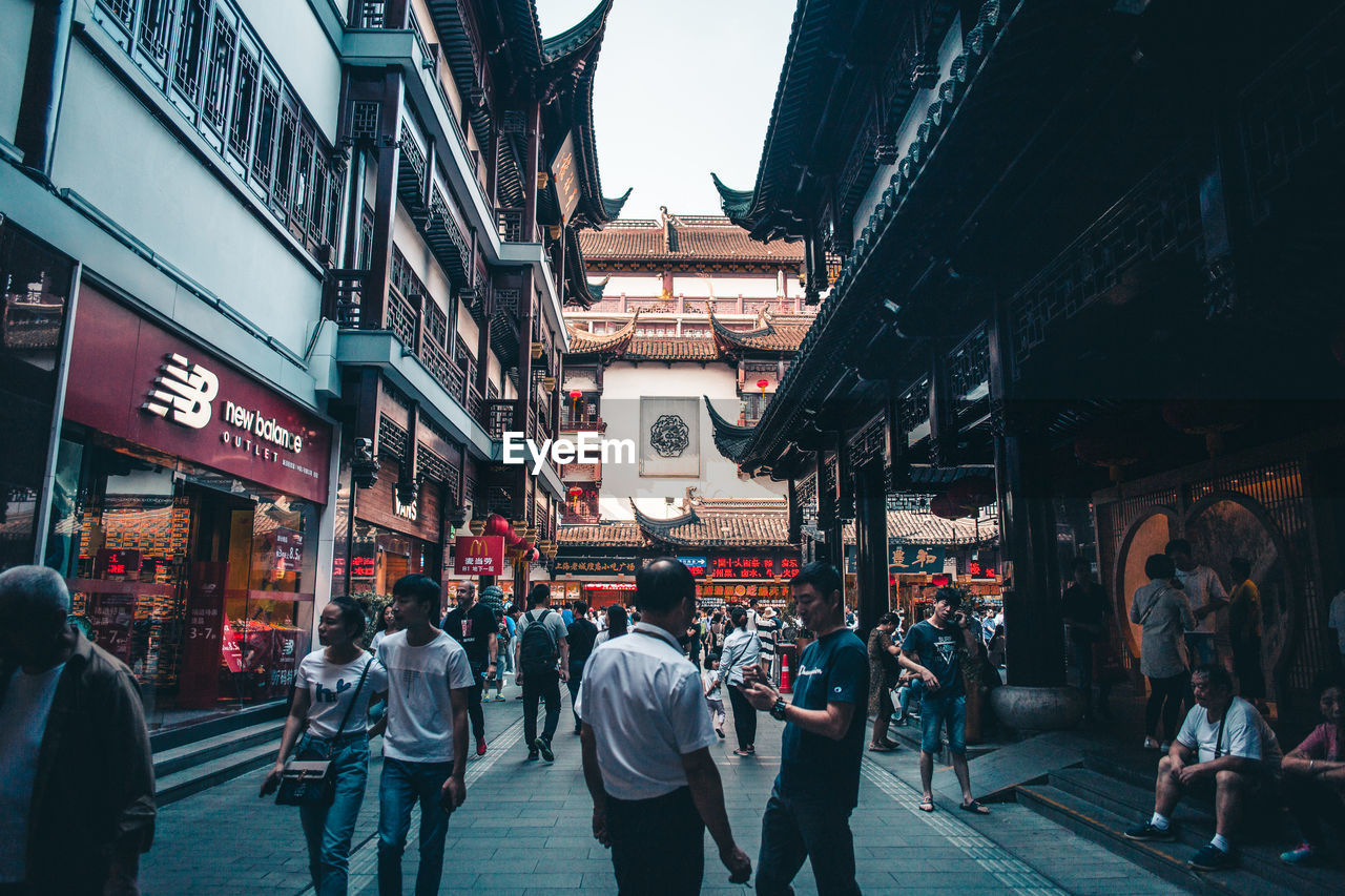 PEOPLE ON STREET IN CITY AT STORE