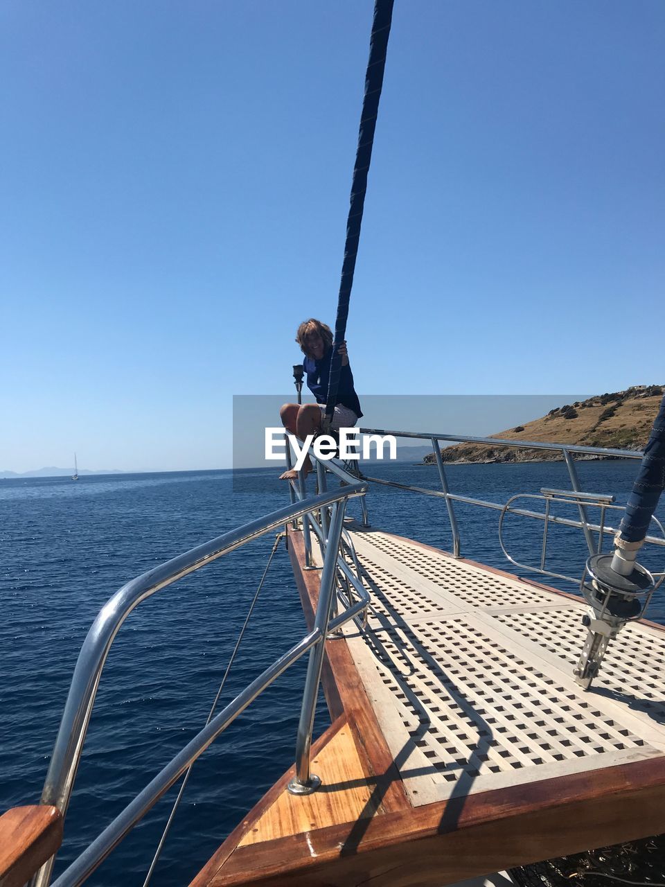 SAILBOAT SAILING IN SEA AGAINST CLEAR SKY