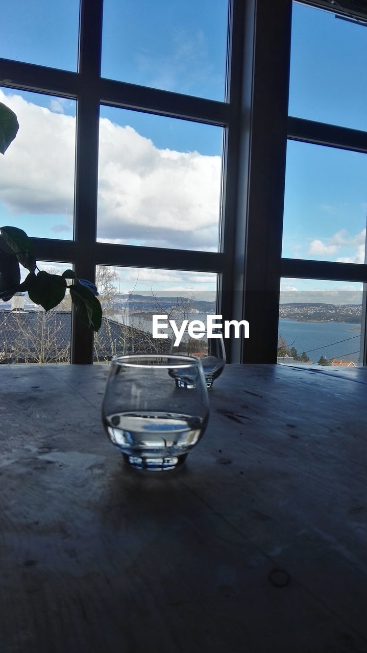 CLOSE-UP OF TABLE BY SEA AGAINST WINDOW