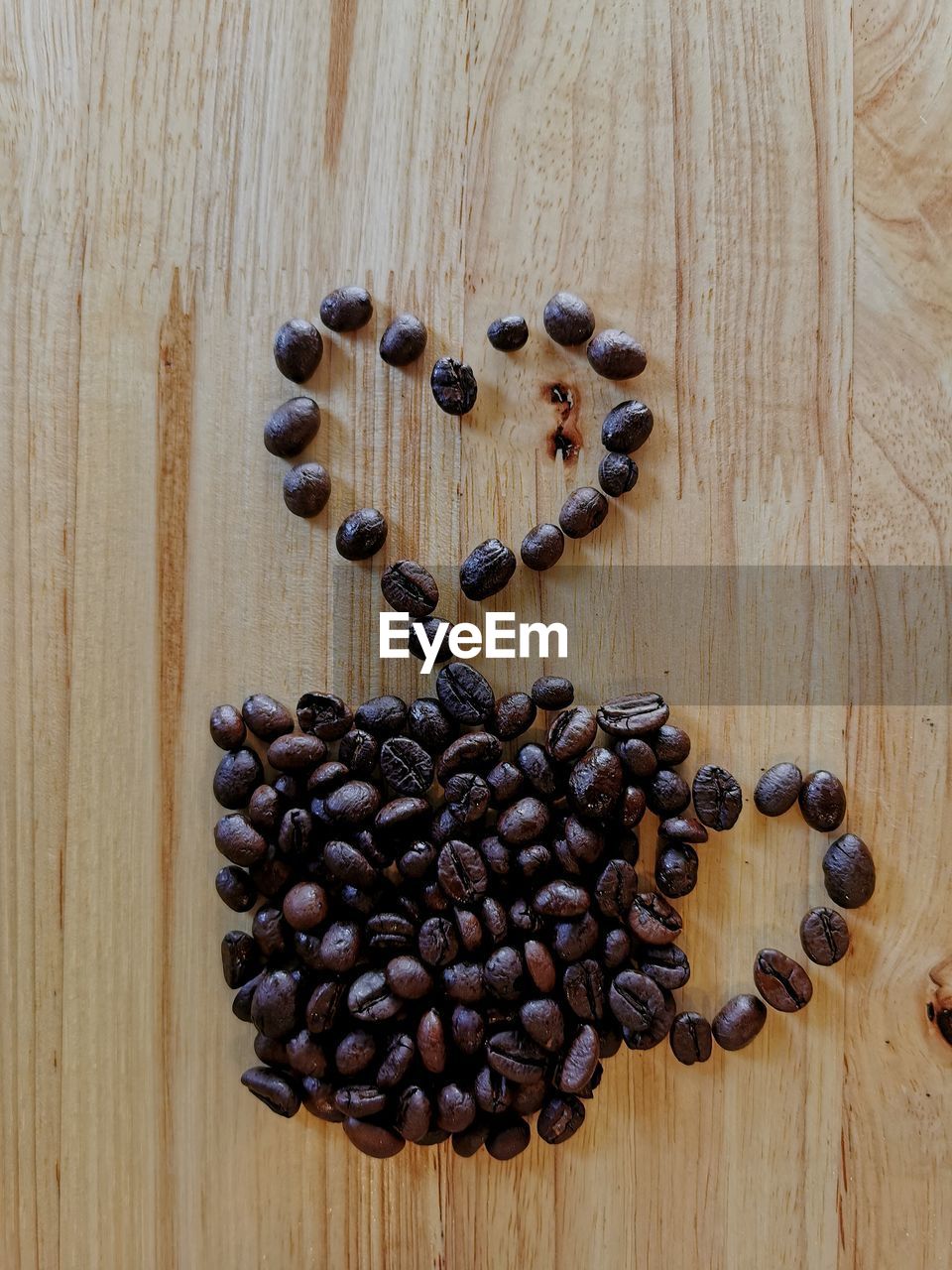HIGH ANGLE VIEW OF COFFEE BEANS ON WOODEN TABLE