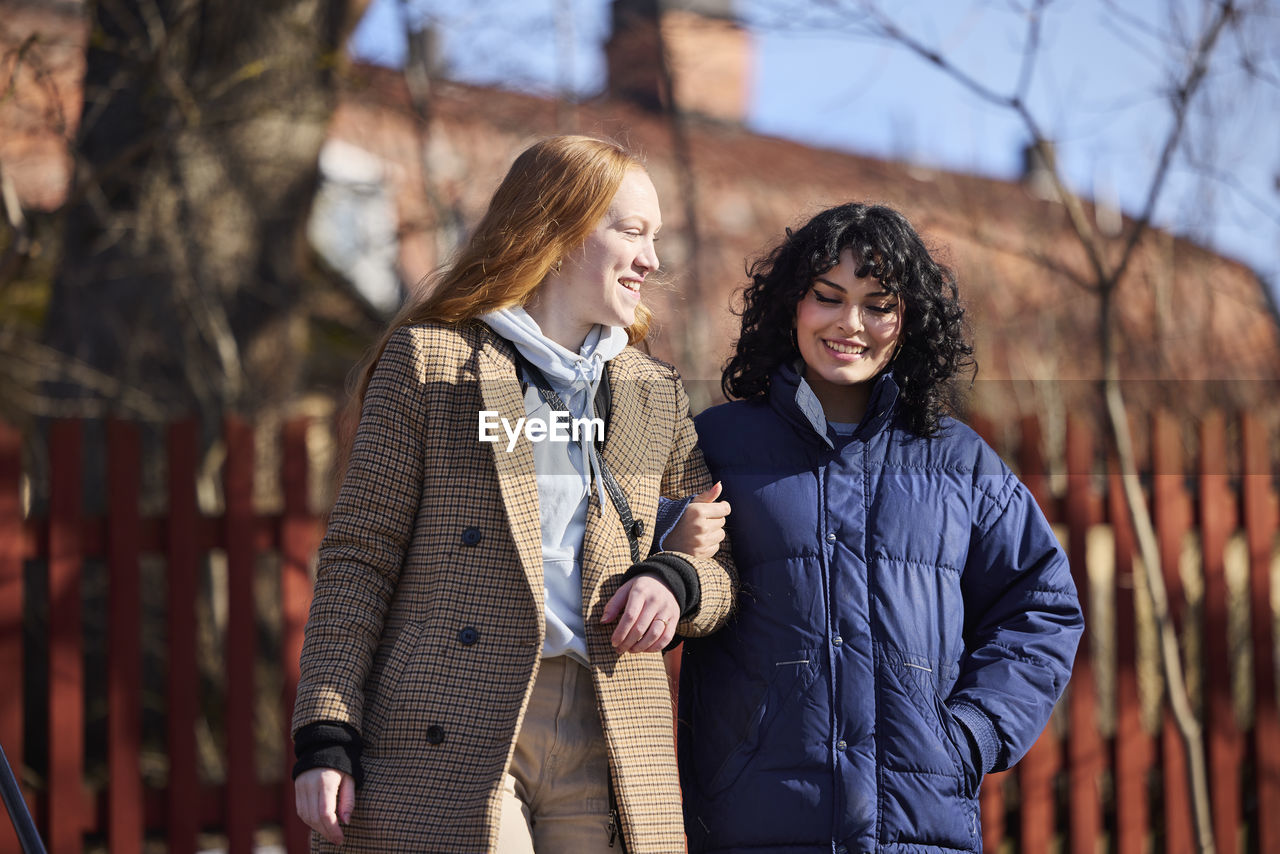 Smiling female friends walking in park