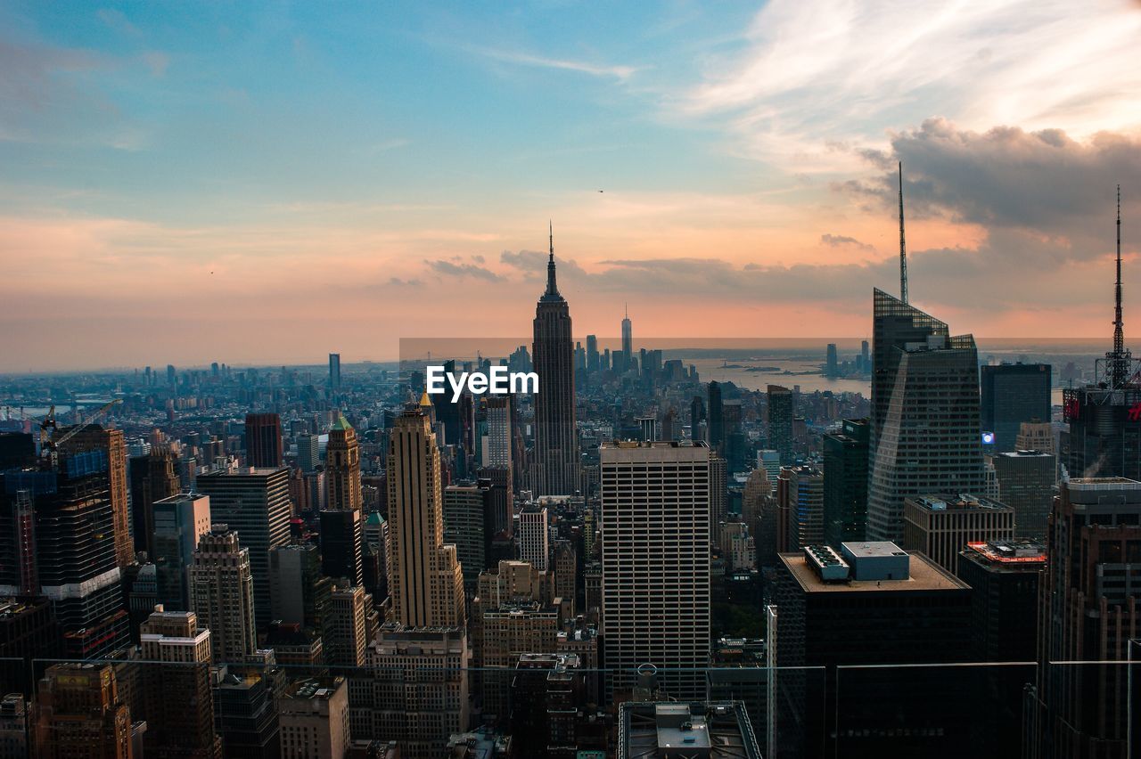 Modern buildings in city against cloudy sky