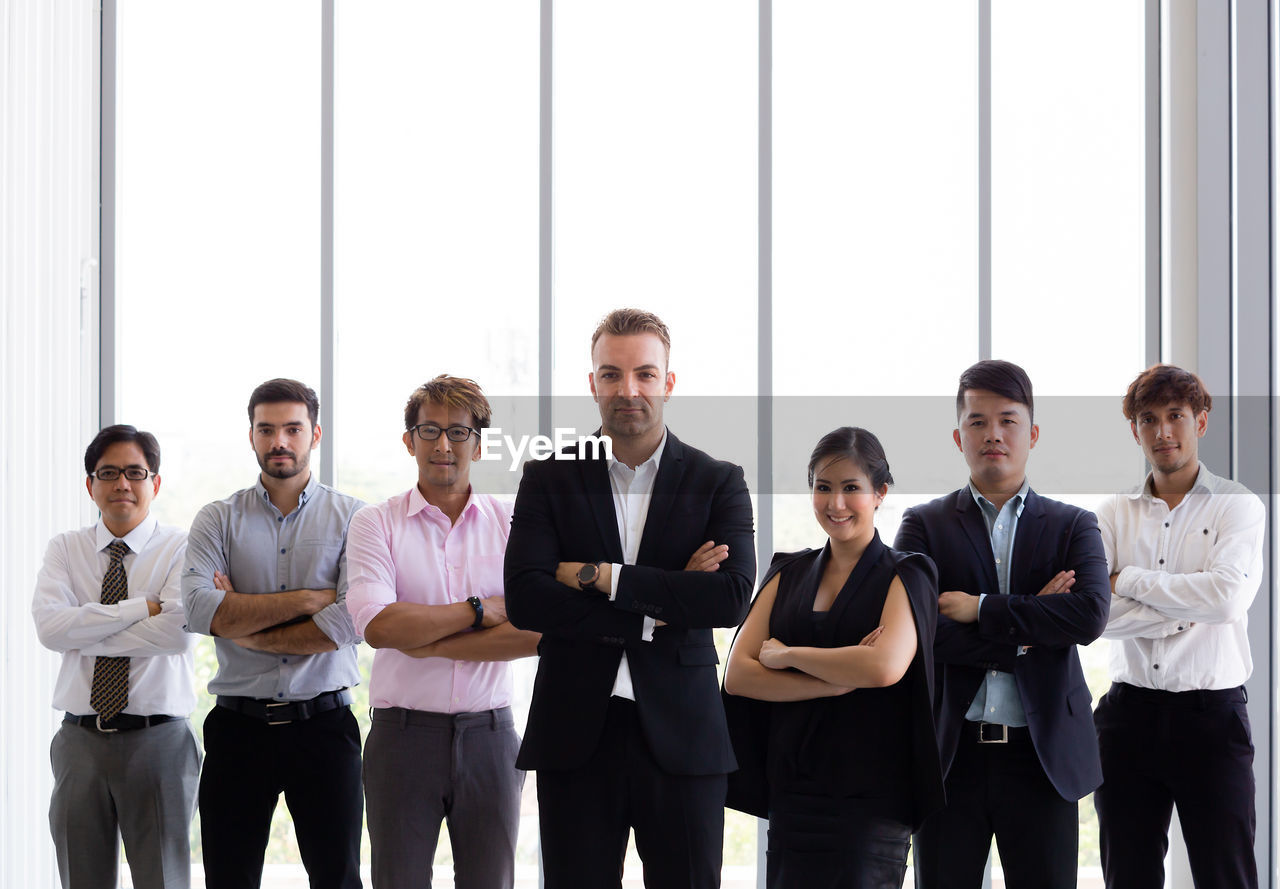 Portrait of confident business colleagues with arms crossed standing at office