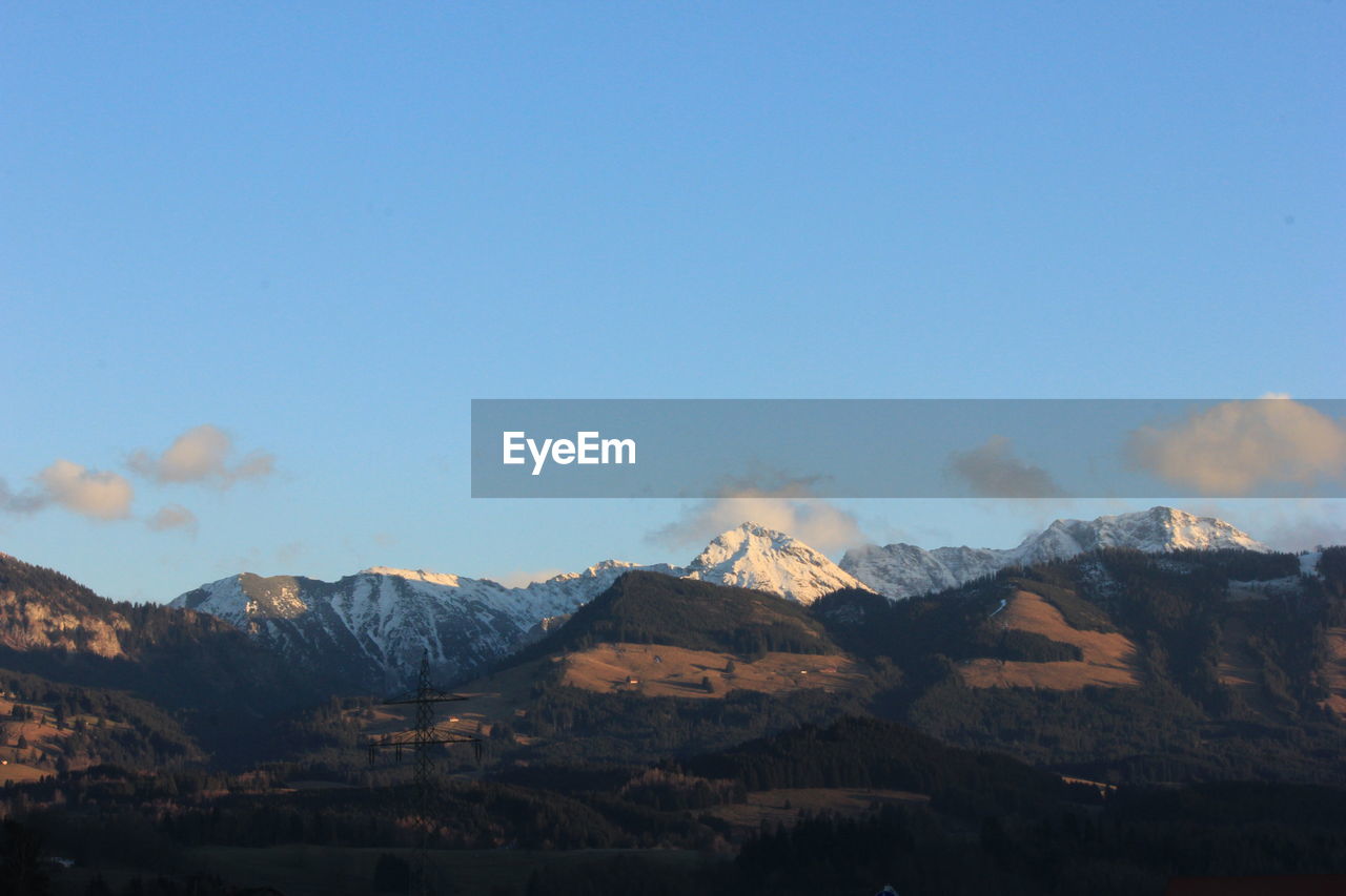 Scenic view of mountains against blue sky