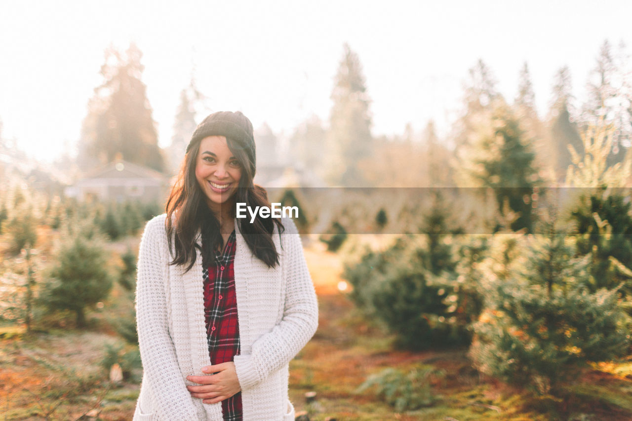 Portrait of smiling young woman standing in farm