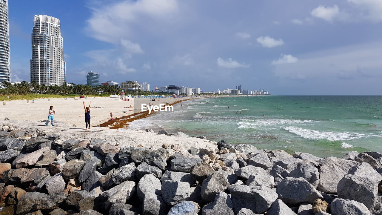 People on beach against sky