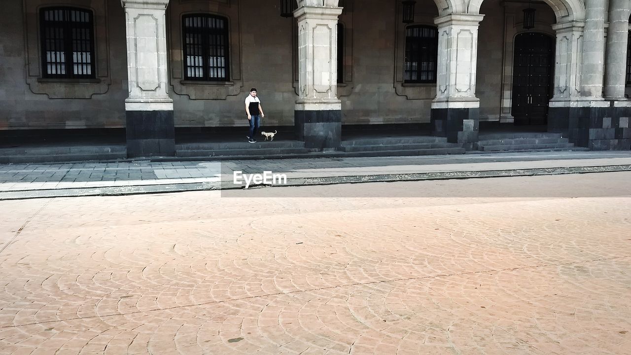 FULL LENGTH OF MAN AT HISTORIC BUILDING