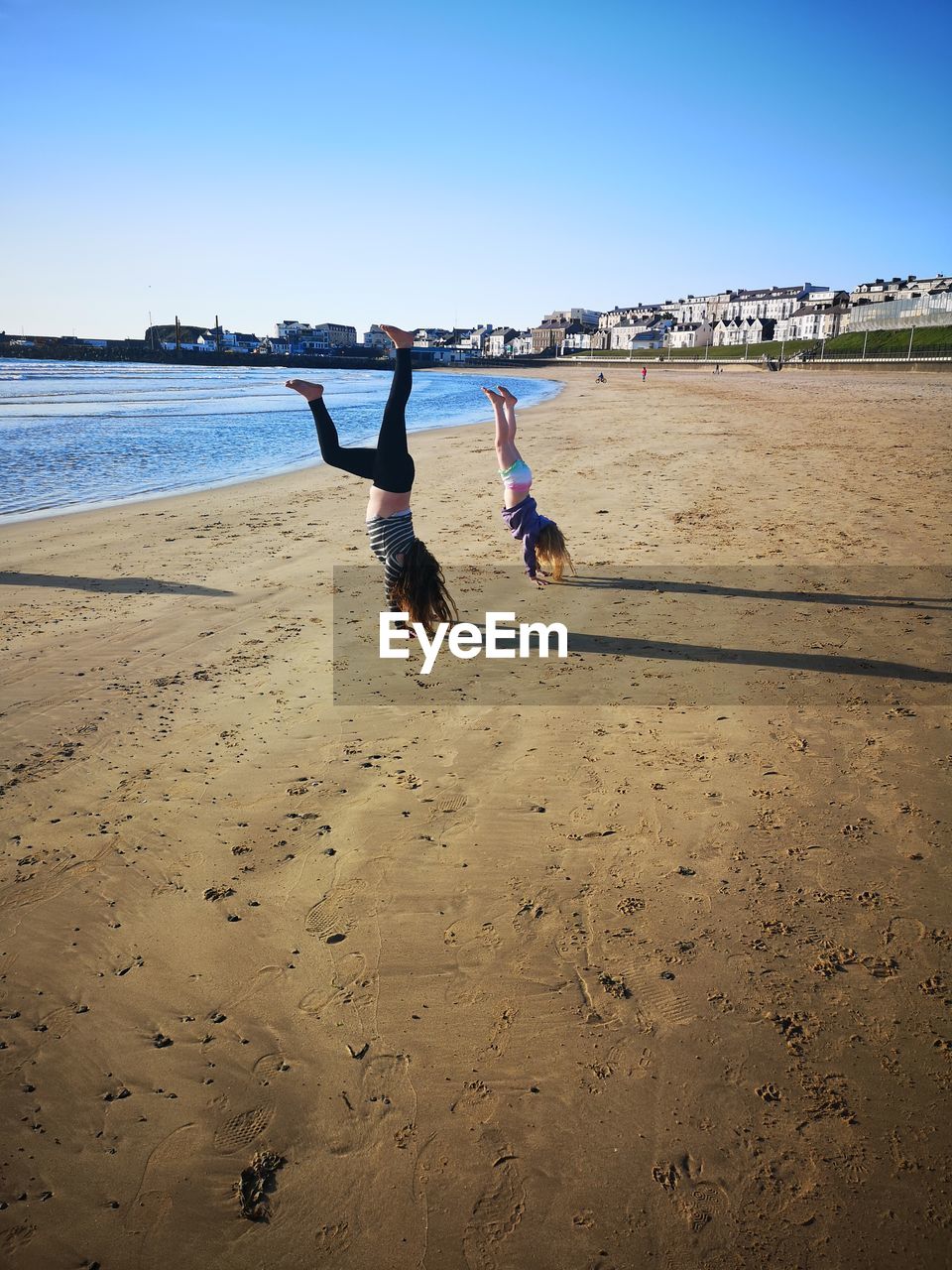 Upside down image of people on beach against sky