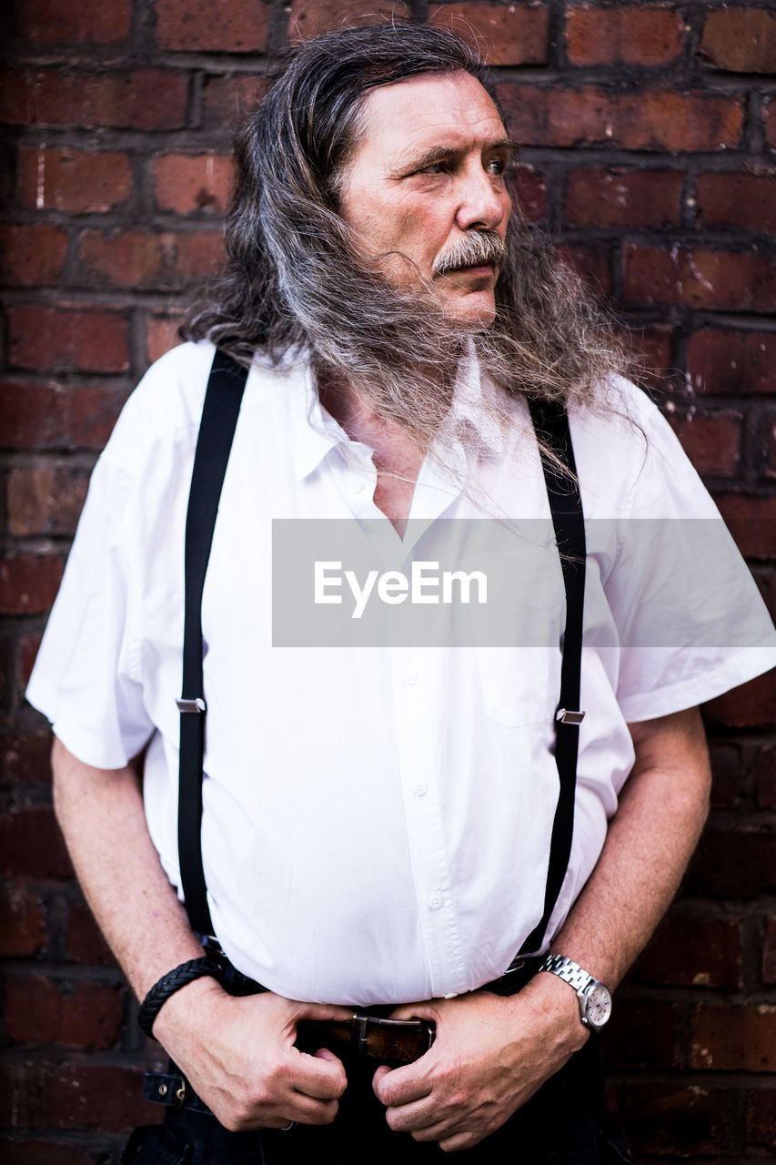 Mid adult man standing against wall