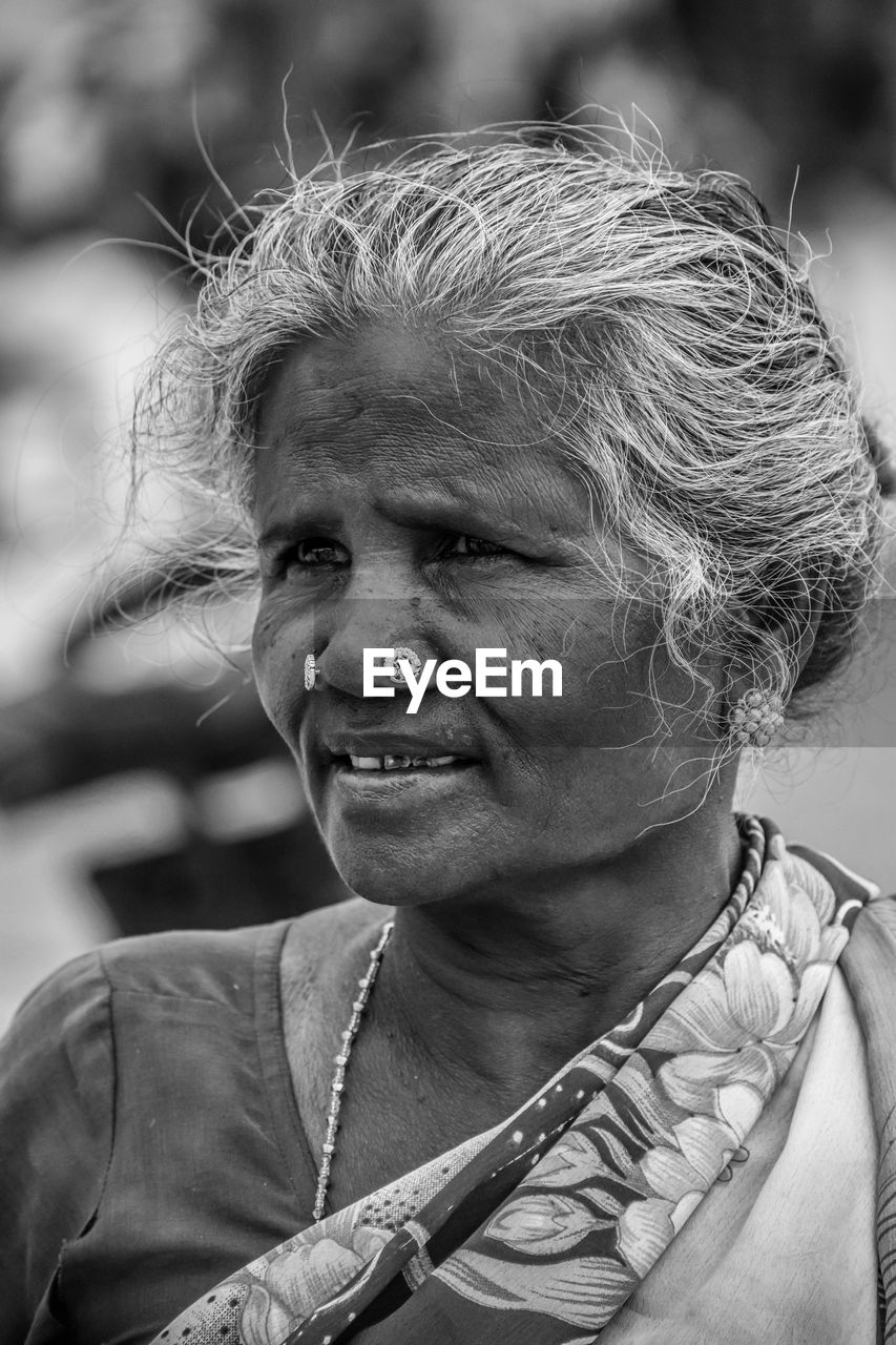 adult, portrait, one person, black and white, person, women, headshot, monochrome, monochrome photography, lifestyles, emotion, senior adult, smiling, female, human face, portrait photography, poverty, jewelry, mature adult, happiness, black, outdoors, necklace, men, focus on foreground, clothing, looking, indigenous culture