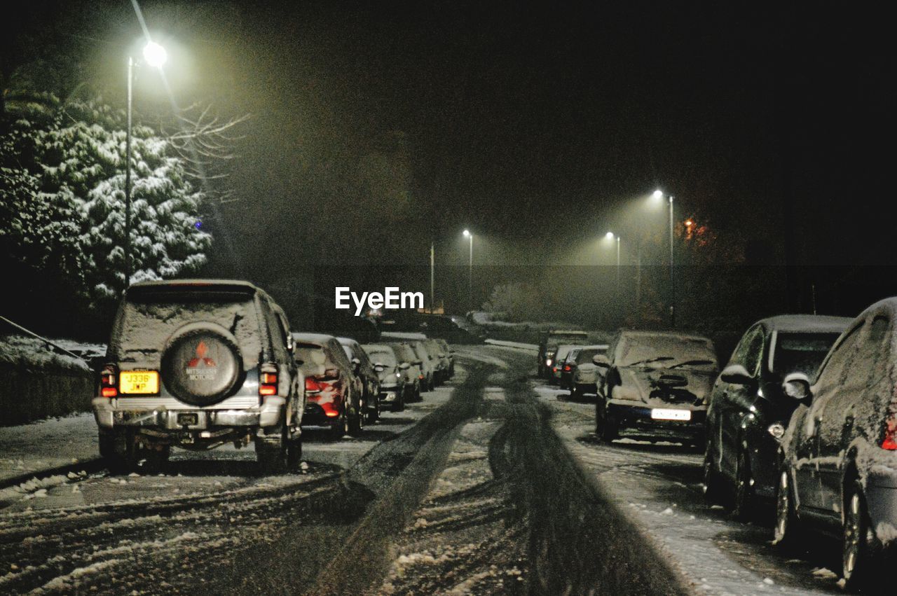 CARS IN ILLUMINATED AT NIGHT