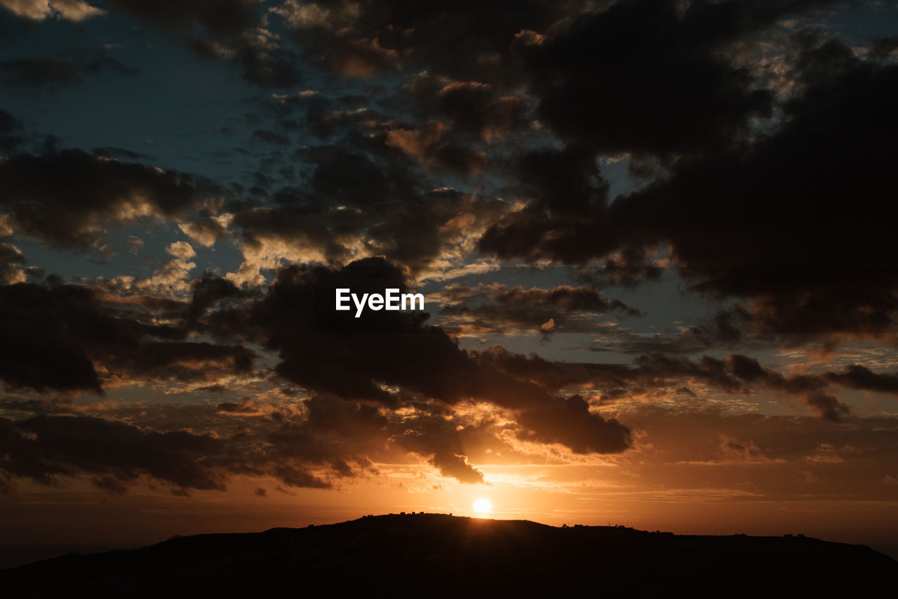 LOW ANGLE VIEW OF DRAMATIC SKY OVER SILHOUETTE MOUNTAINS