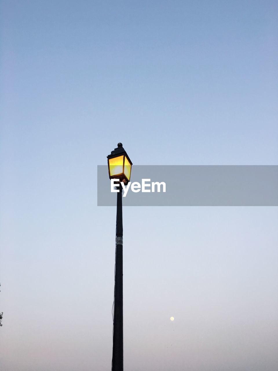 LOW ANGLE VIEW OF ILLUMINATED STREET LIGHT AGAINST CLEAR SKY