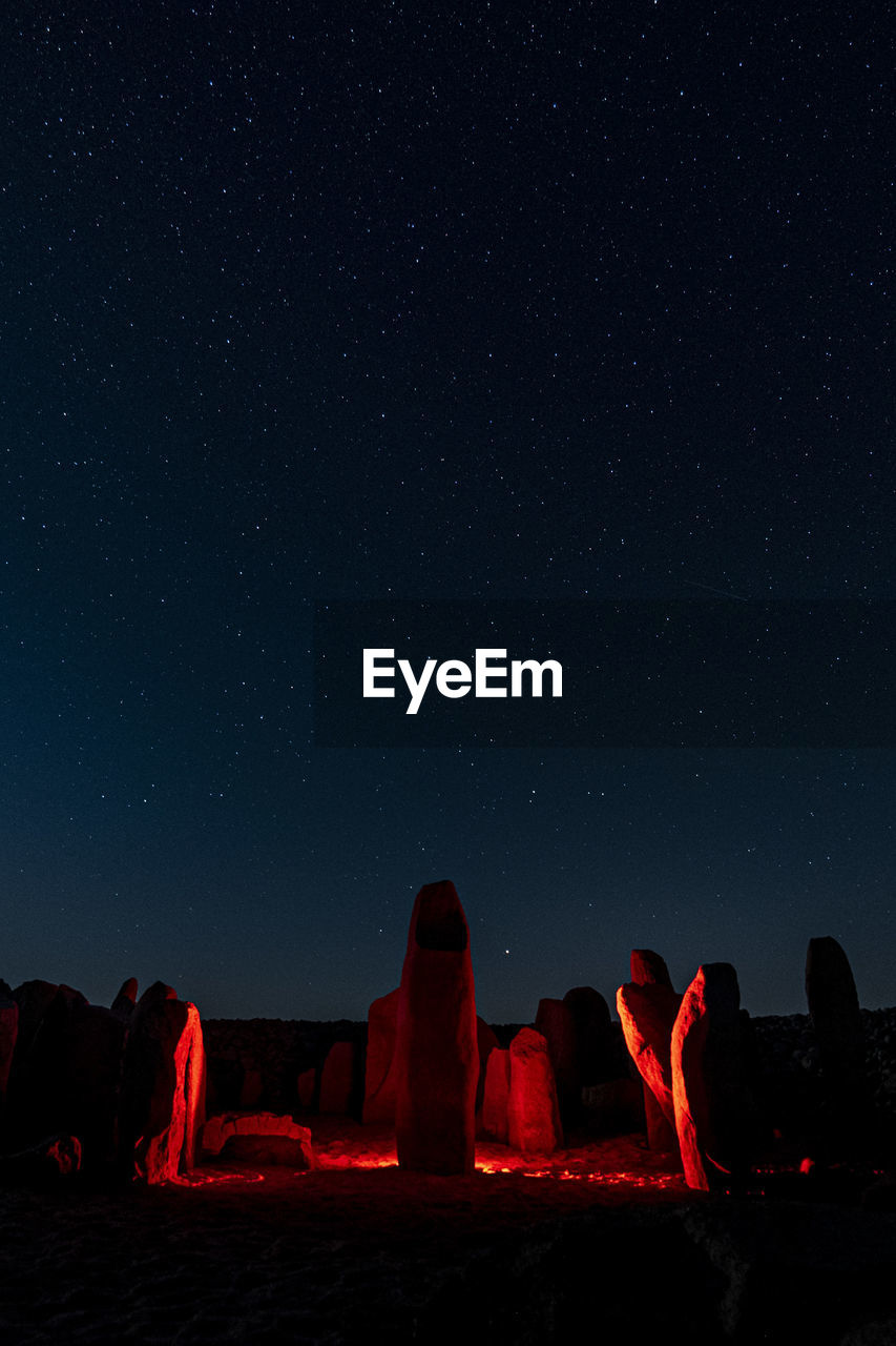 View of illuminated rock formation against sky at night