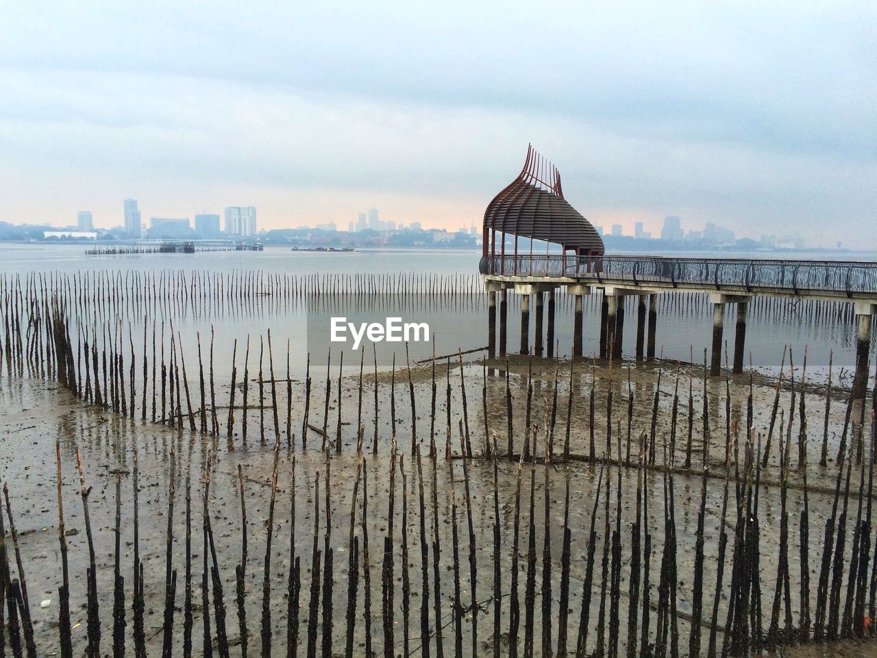 Gazebo on river against buildings in city