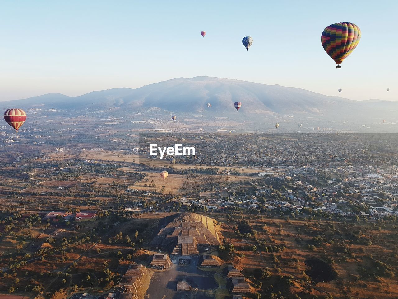 Aerial view of hot air balloons flying in city