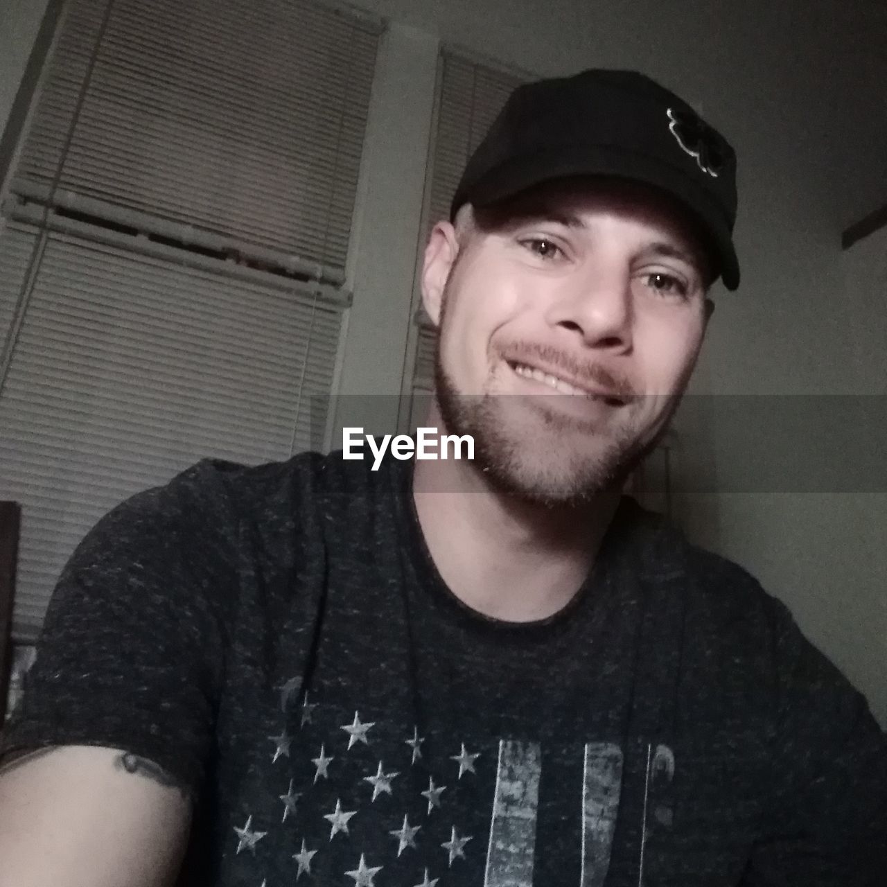 PORTRAIT OF SMILING YOUNG MAN WEARING HAT