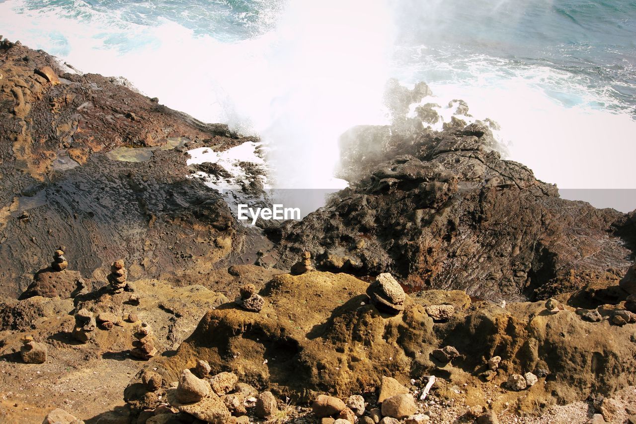 SCENIC VIEW OF WATERFALL AGAINST ROCKS