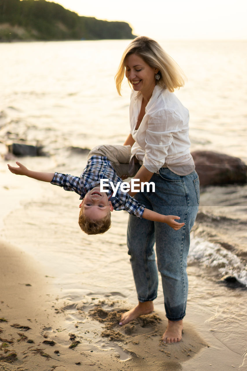 Mother and son having fun and playing at the seaside. summer vacation.