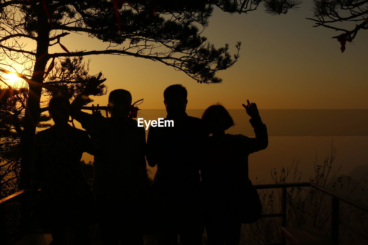 LOW ANGLE VIEW OF SILHOUETTE PEOPLE AGAINST SKY AT SUNSET